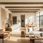 Open concept living room and kitchen with continuous light oak flooring and wooden ceiling beams.